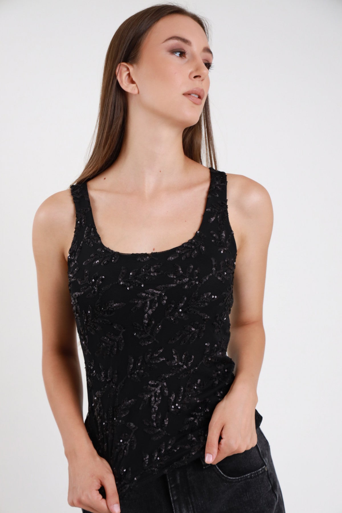 Top paillettes nero donna scollo tondo spalline larghe racer back motivo floreale ramoscelli tono su tono - dettaglio frontale mano in tasca jeans neri
