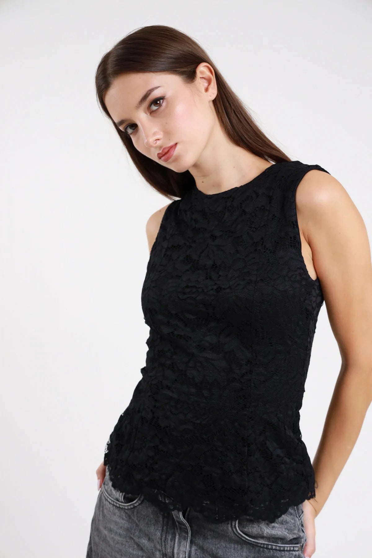 Top pizzo nero senza maniche aderente - modella vista frontale con jeans grigi