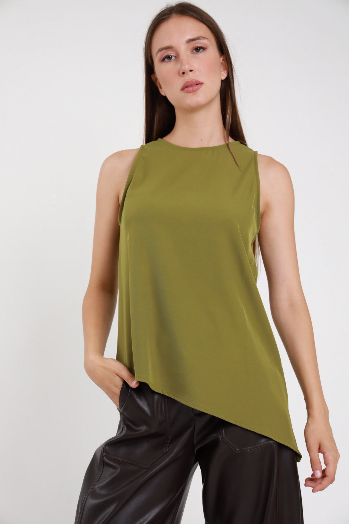 Top asimmetrico verde oliva donna spalle strutturate fondo a punta - vista frontale con pantaloni in ecopelle neri