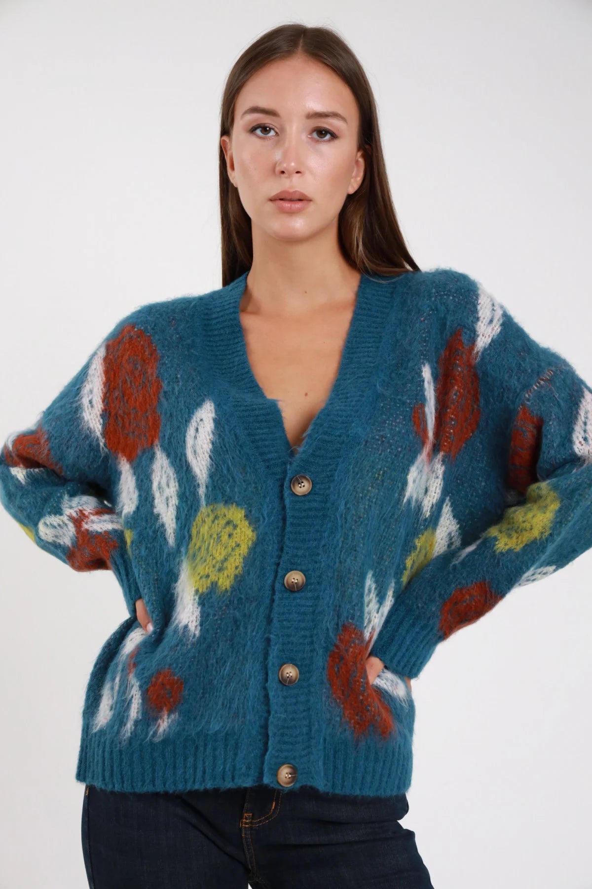Cardigan mohair jacquard floreale teal petrolio scollo V bottoni dorati - modella busto frontale mani sui fianchi sguardo frontale jeans navy capelli castani lisci