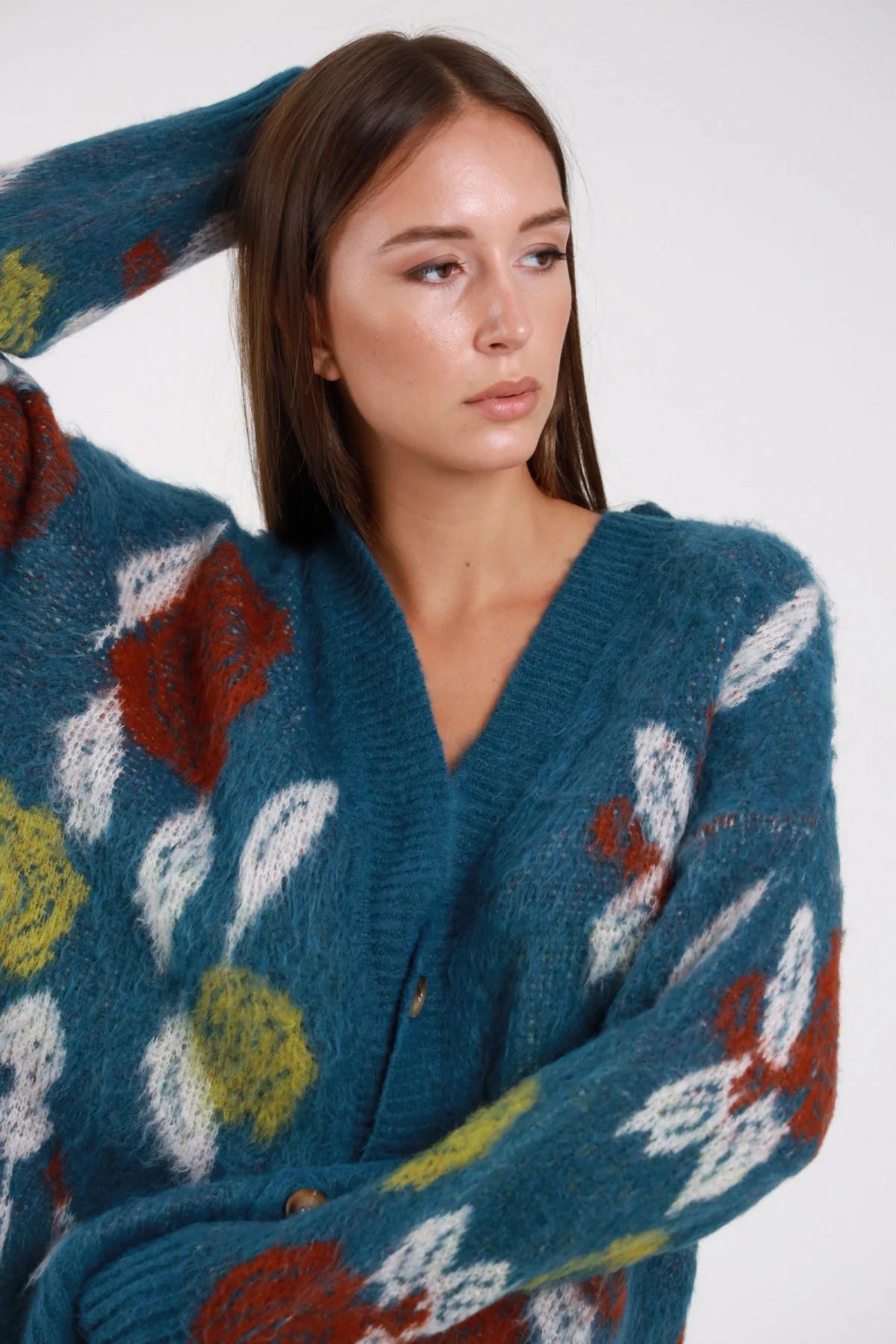 Cardigan mohair jacquard teal petrolio multicolor dettaglio motivo - modella busto tre quarti mano in testa sguardo laterale jeans navy capelli castani lisci