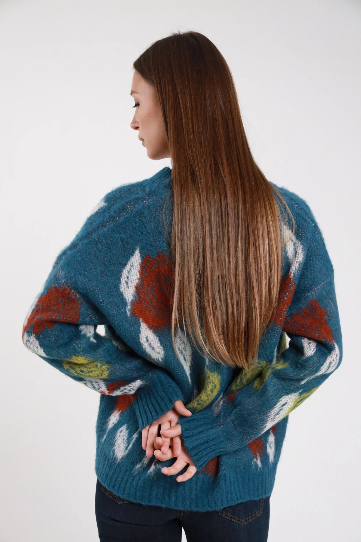 Cardigan mohair jacquard floreale teal petrolio oversize - modella retro intera mani intrecciate sguardo laterale jeans navy capelli castani lisci
