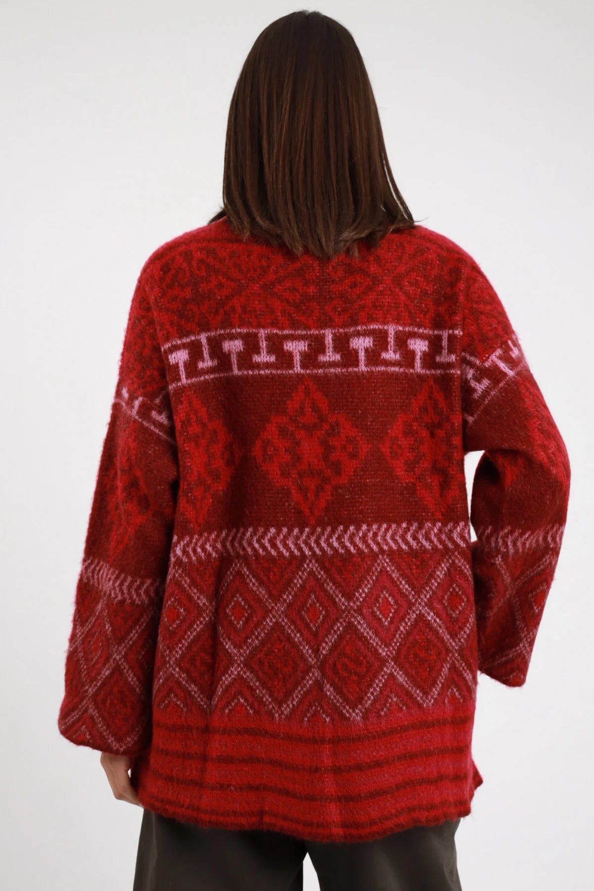Cardigan jacquard Susy Mix Pre-Fall rosso bordeaux motivi jacquard geometrici etnici fasce rombi azteco banda decorativa T spalle colletto V revers manica ampia silhouette oversize lunga posteriore intera - modella posteriore intera capelli scuri lisci sfondo bianco motivi jacquard dettaglio retro ben visibile pantalone abbinato