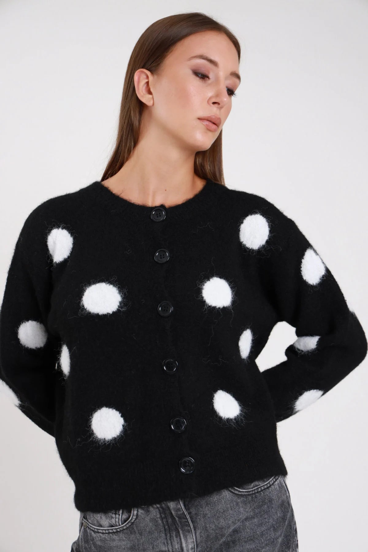 Cardigan pois nero bianco fluffy eyelash frontale busto sguardo basso maxi pois jacquard tridimensionali bianchi girocollo costina abbottonatura bottoni neri dropped shoulder - modella frontale busto sguardo basso jeans grigio capelli castani lisci