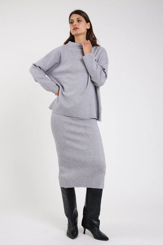 Completo coordinato gonna midi pencil coste rib maglia oversize batwing mock neck nero retro intera mani fianchi capelli lunghi lisci - modella retro intera mani fianchi capelli castani lisci lunghi sfondo bianco mules tacco nere