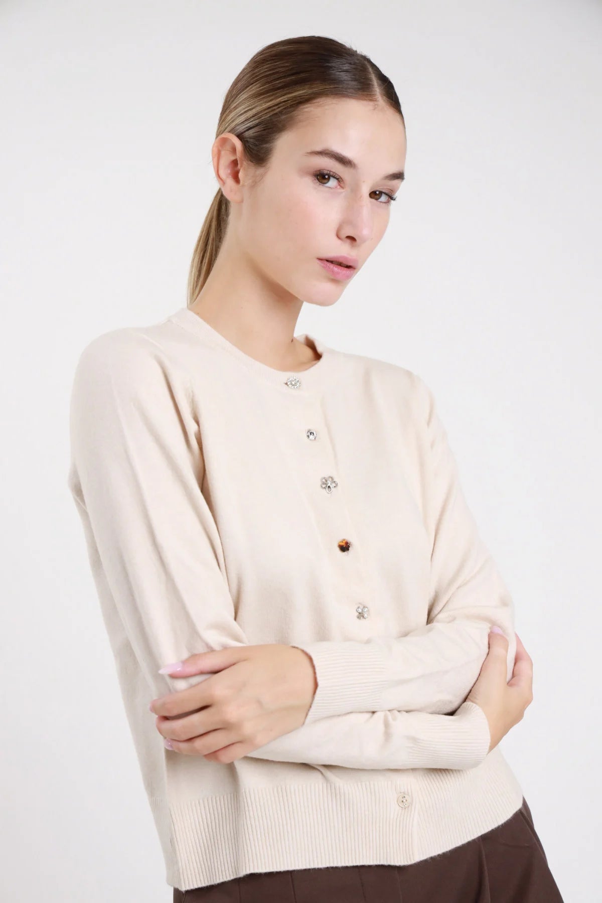 Cardigan coreana dettaglio bottoni gioiello misti strass cristallo fiore dorato tartaruga perla croce - modella busto ravvicinato frontale capelli castani raccolti