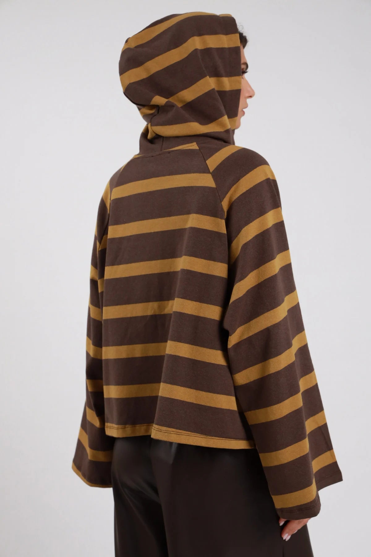 Hoodie Righe Larghe Patch Testa Tigre marrone cioccolato ocra senape 77% cotone cappuccio indossato posteriore 3/4 laterale manica batwing larghissima silhouette crop maxi oversize - modella intera 3/4 posteriore laterale cappuccio testa posa statica capelli castani sfondo bianco pantaloni ecopelle marrone