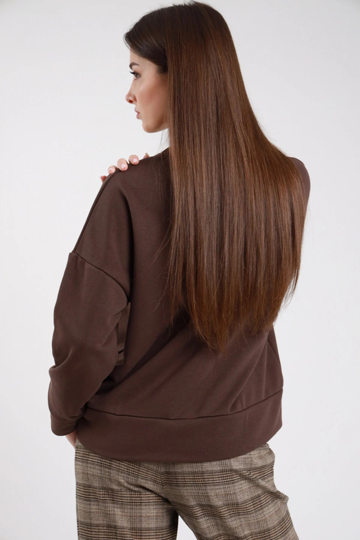 Felpa oversize cotone felpato marrone cioccolato maxi patch ricamo paillettes tigre ruggente oro nero rosso girocollo tondo retro intera capelli lunghi lisci - modella retro intera mano spalla sguardo laterale capelli castani lisci lunghi sfondo bianco pantaloni check beige