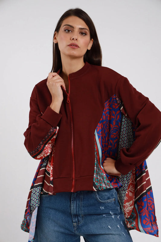 Bomber Zip Foulard Patchwork bordeaux vino 65% cotone collo coreana rialzato maniche foulard patchwork multicolor floreale rosso geometrico blu verde righe inserti foulard fianco davanti zip frontale polsino costina bordeaux silhouette bomber crop - modella busto 3/4 frontale posa mano zip sguardo laterale soft capelli castani lisci sfondo bianco jeans denim chiaro