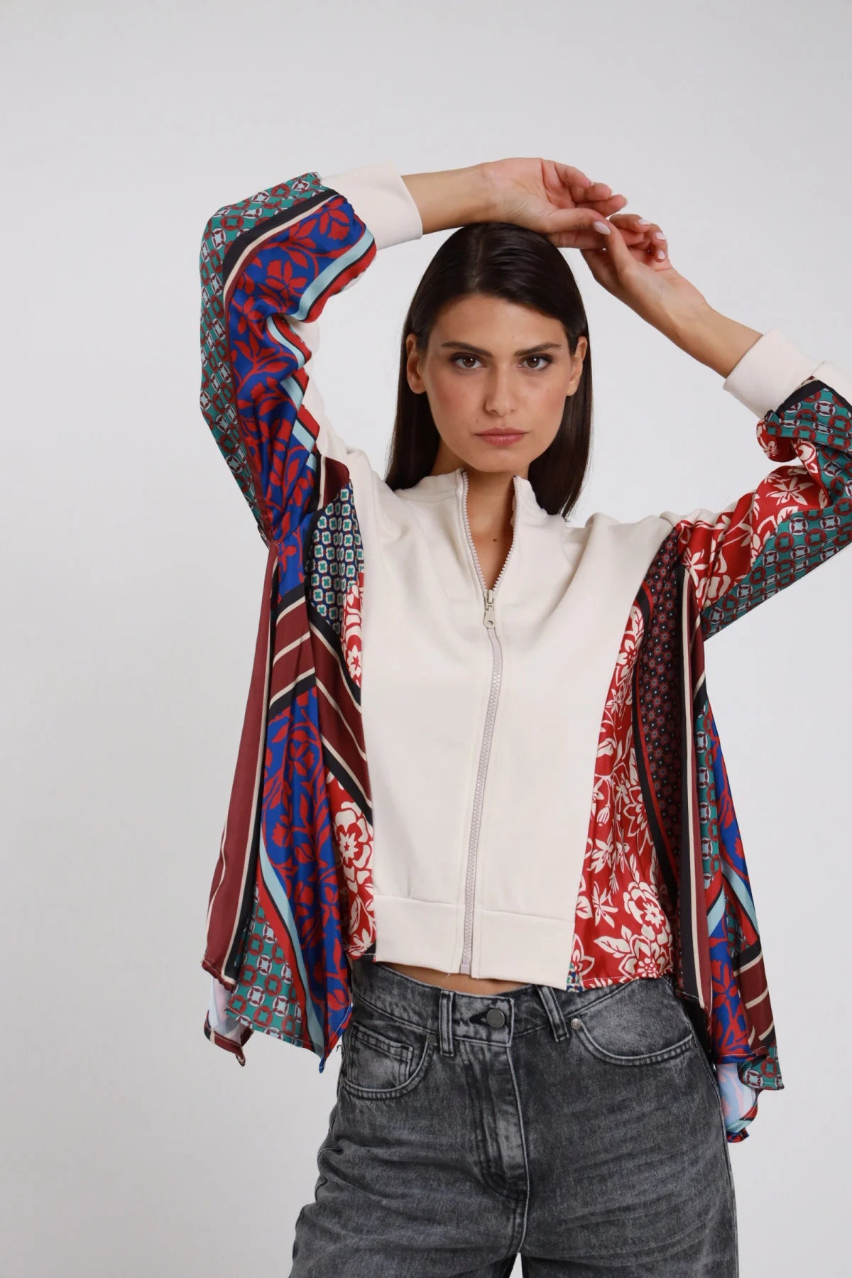 Bomber Zip Foulard Patchwork panna écru 65% cotone collo coreana maniche interamente foulard patchwork multicolor floreale rosso geometrico blu verde acqua righe bordeaux corpo panna pulito zip frontale polsino costina - modella busto frontale posa mani testa braccia alzate sguardo intenso frontale capelli castani lisci sfondo bianco jeans grigio