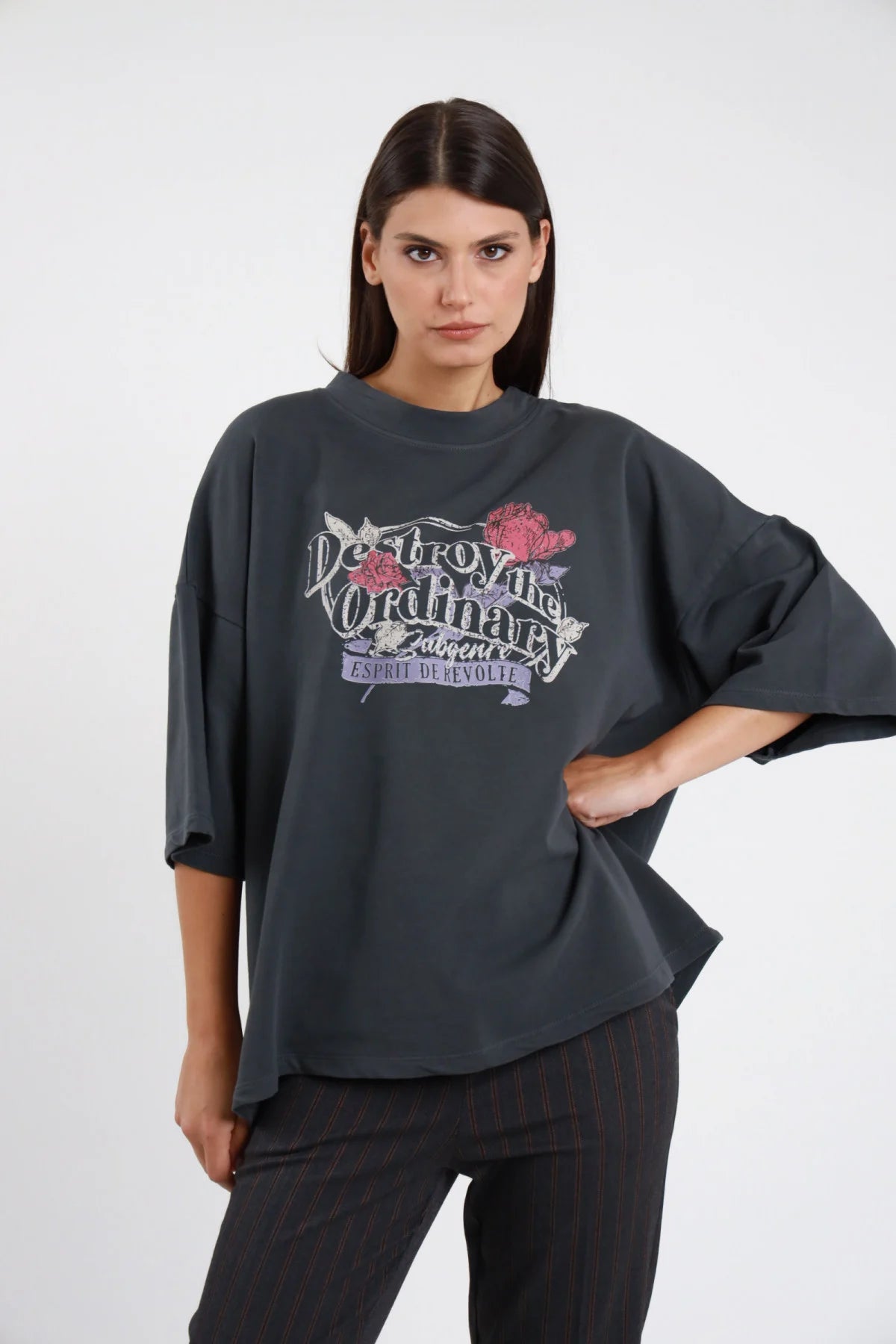 T-shirt felpa stampata Susy Mix Pre-Fall grigio antracite stampa rock vintage rose gotiche Destroy Ordinary girocollo drop manica 3/4 oversize boxy seduta 3/4 laterale sguardo alto - modella seduta pavimento 3/4 laterale sguardo alto capelli scuri lisci sfondo bianco pantaloni grigio abbinati