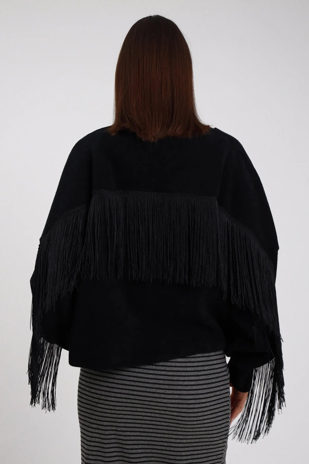 Felpa Oversize Frange Tasca Paillettes nera girocollo posteriore frange lunghissime retro intero coprono schiena effetto cape frangiata frange maniche - modella busto posteriore posa statica capelli castani sfondo bianco gonna midi righe grigia coordinata