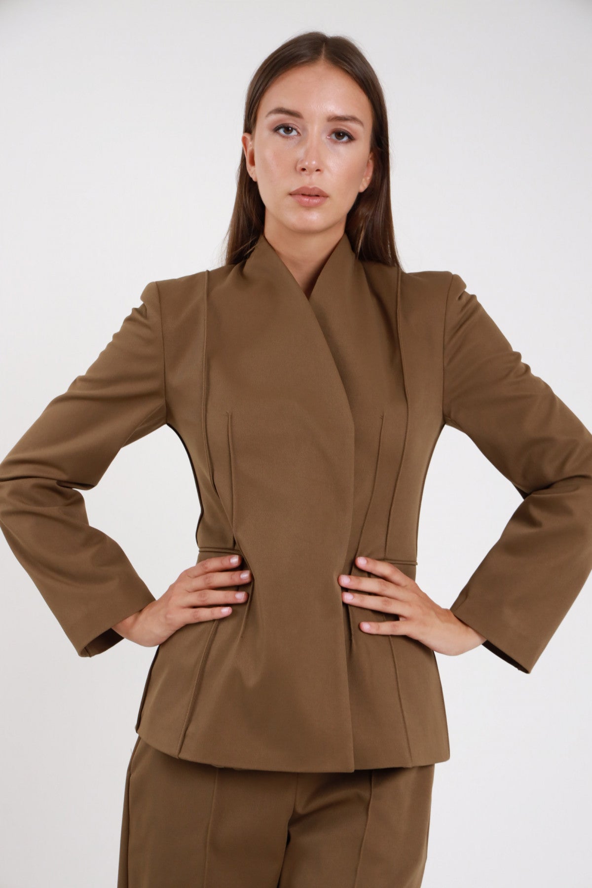 Blazer asimmetrico kaki militare nervature - modella busto frontale mani sui fianchi con pantaloni palazzo kaki coordinati