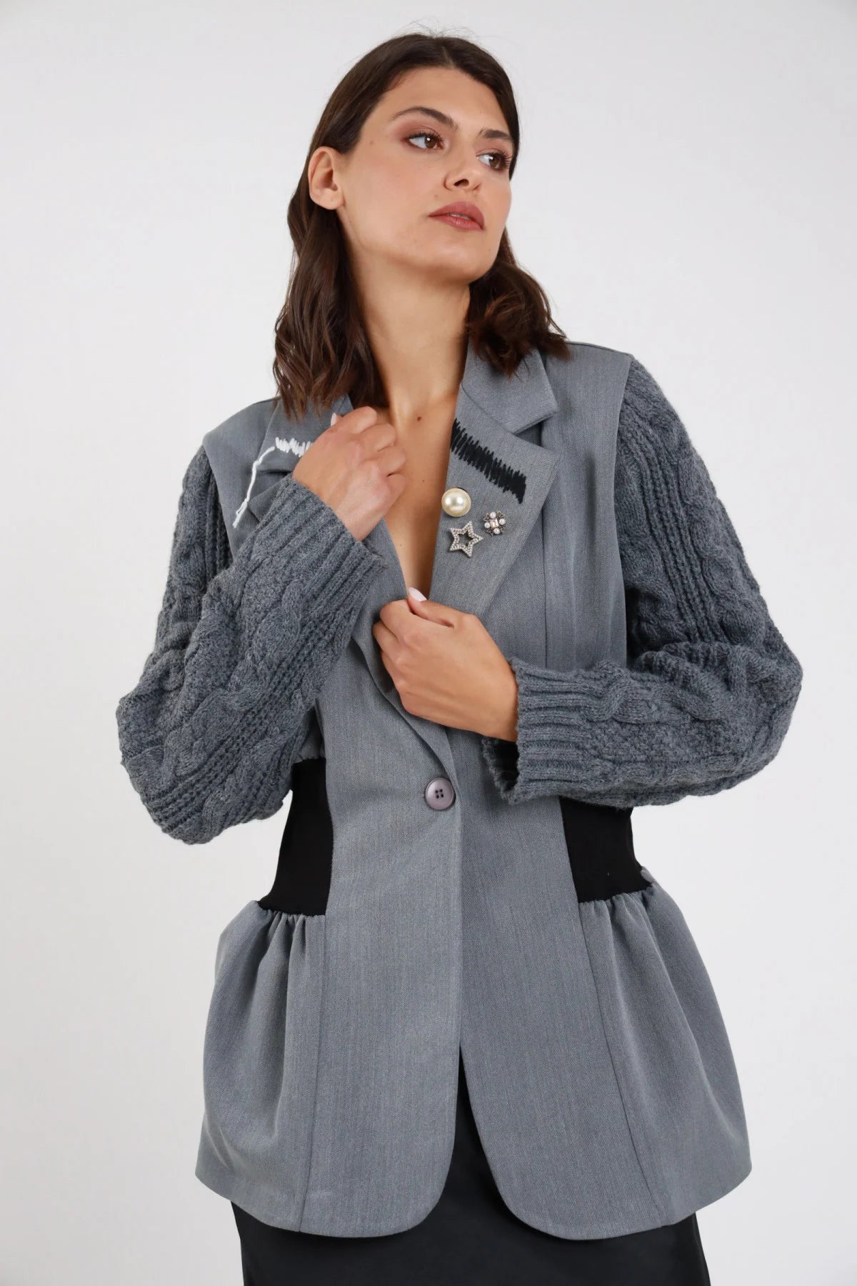 Blazer sartoriale grigio ardesia maniche maglia trecce volumetriche fascia elastica nera vita peplum svasato retro intera - modella retro intera capelli castani medi sfondo bianco gonna nera