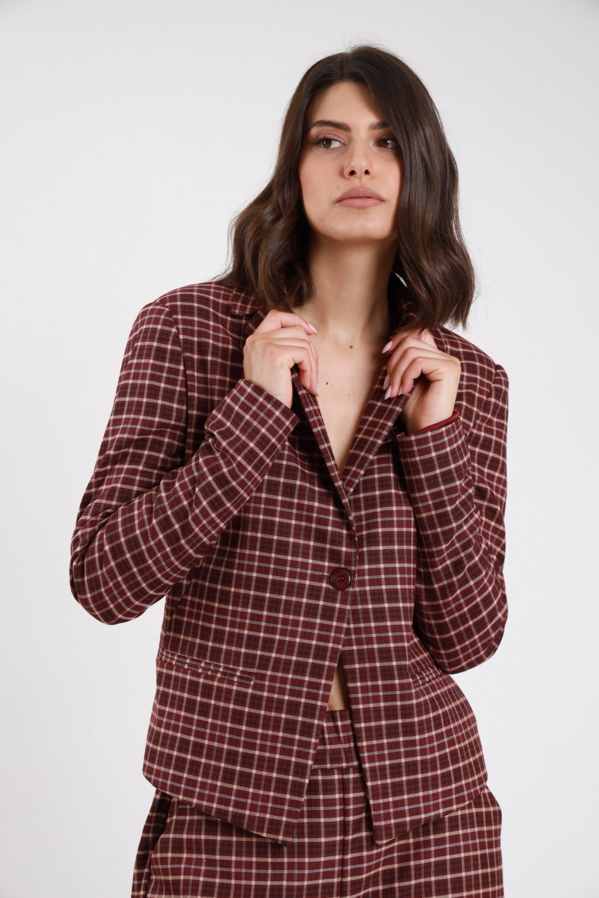 Blazer Corto Check tartan bordeaux ruggine quadri panna revers V 2 bottoni tasche filetto patta spalle strutturate frontale busto mani revers - modella frontale busto mani revers sguardo laterale capelli castani scuri sfondo bianco pantalone check bordeaux
