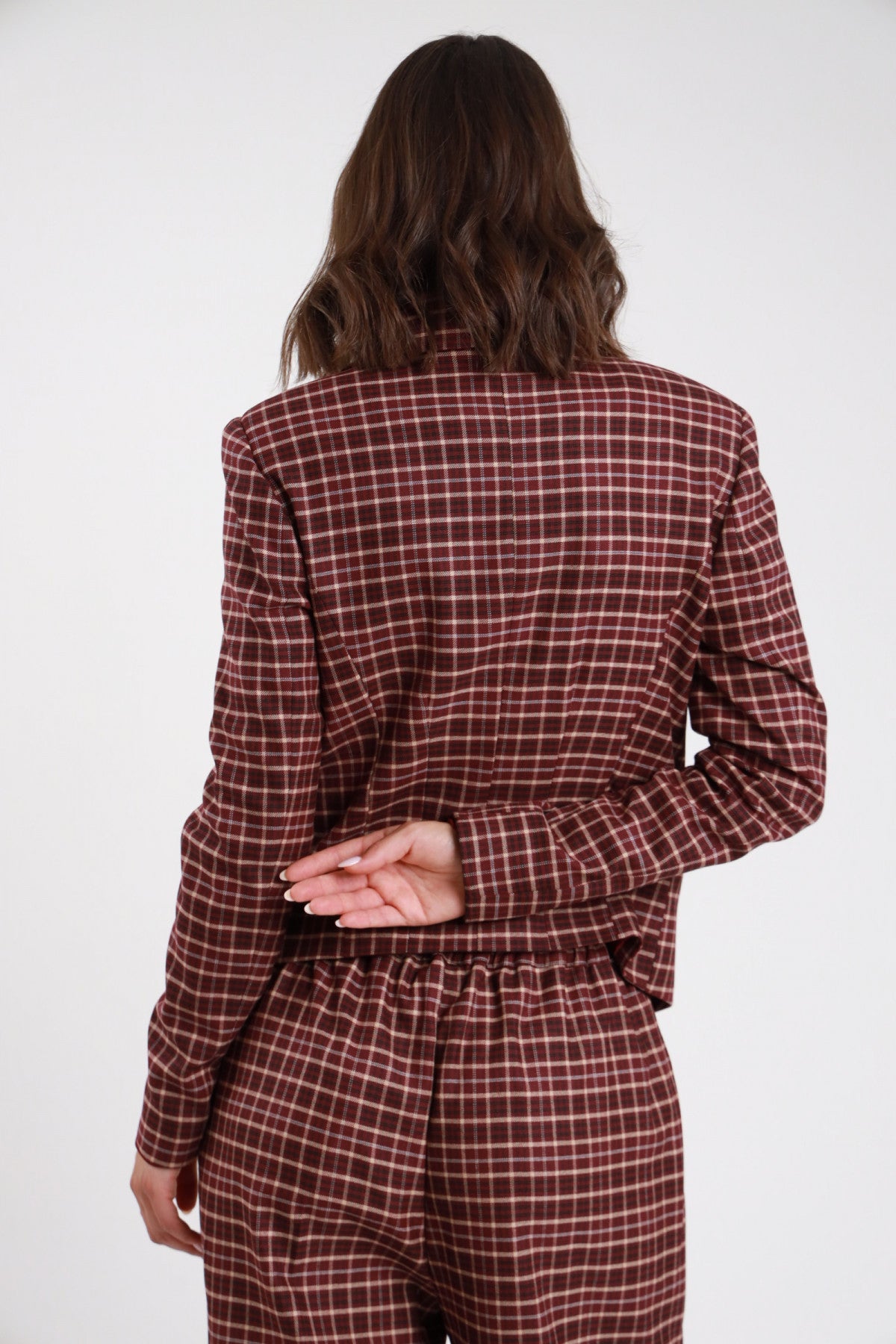 Blazer Corto Check tartan bordeaux ruggine quadri panna revers V 2 bottoni tasche filetto patta spalle strutturate retro intera mani giunte dietro schiena - modella retro intera mani giunte dietro schiena sguardo laterale capelli castani scuri sfondo bianco pantalone check bordeaux