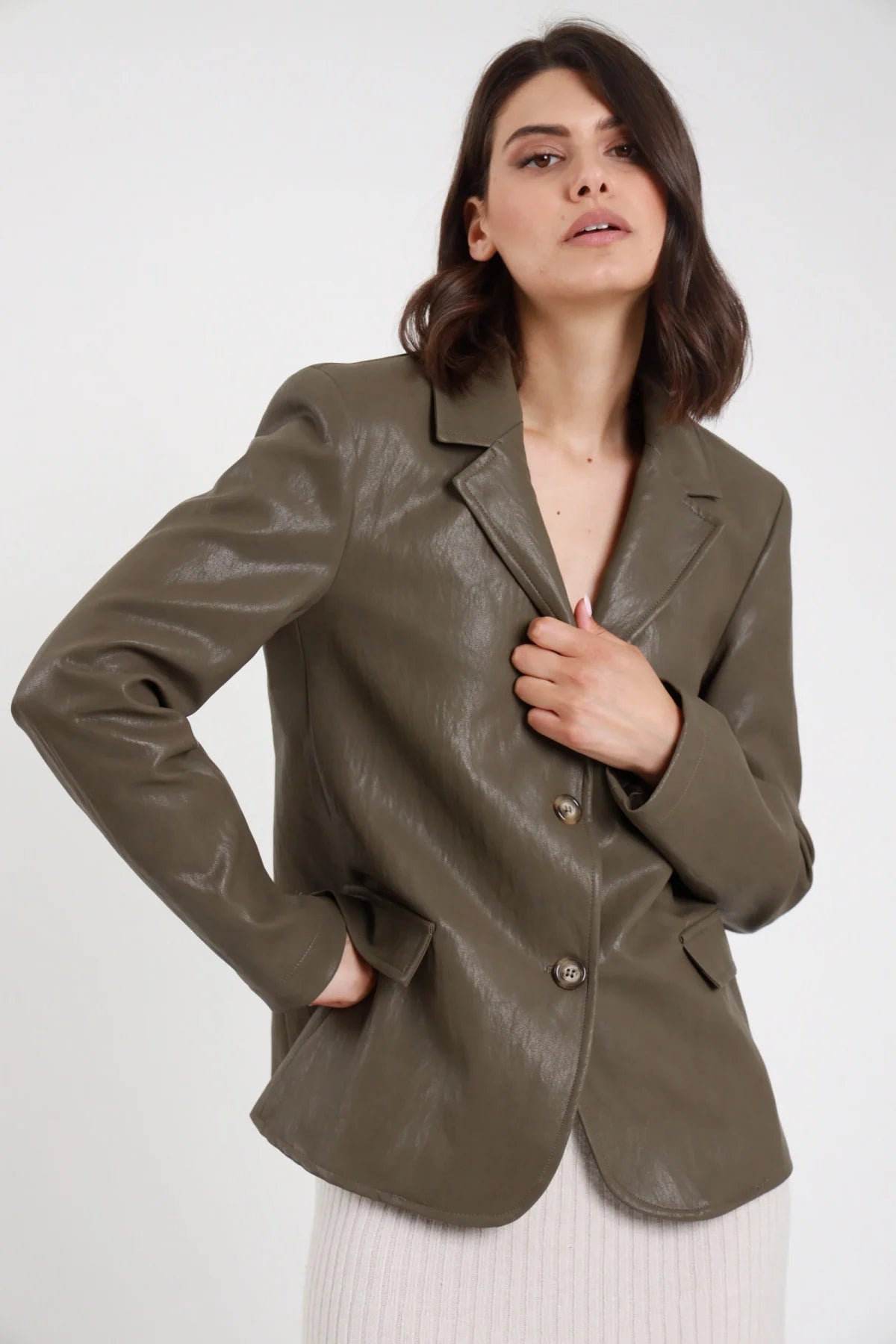 Blazer Monopetto Ecopelle verde militare khaki texture crinkled vintage revers V notched 2 bottoni tasche patta spalle strutturate busto frontale mano tasca - modella busto frontale mano tasca sguardo alto laterale capelli castani sfondo bianco gonna maglia panna ribbed