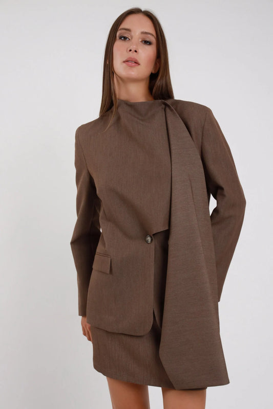 Blazer Scialle marrone cioccolato colletto alto scialle mantella drappeggiata laterale monobottone dorato tasca pattina spalle strutturate manica slim busto frontale 3/4 sguardo camera - modella busto frontale 3/4 sguardo camera capelli castani lisci sfondo bianco minigonna marrone coordinata
