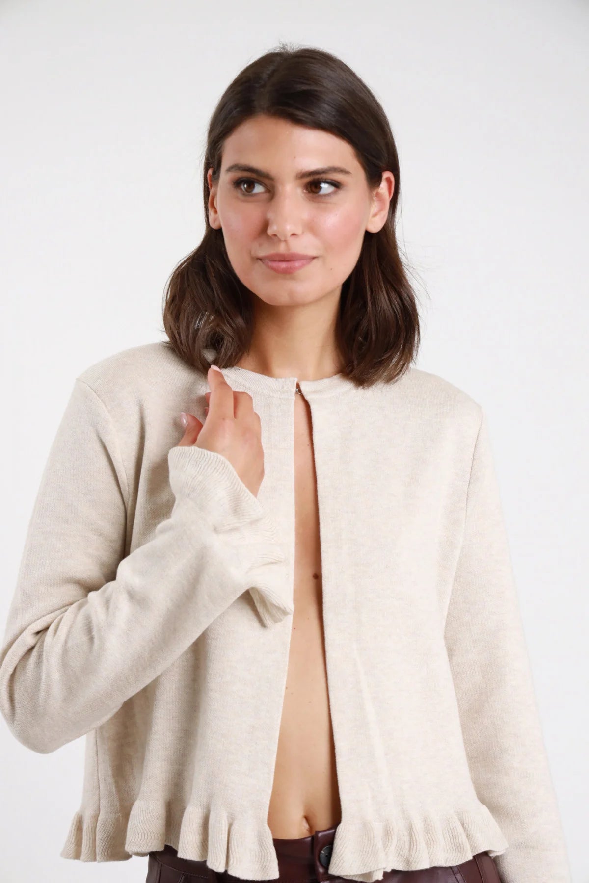 Giacchino gale maglia boucle panna ecru frontale busto mano spalla girocollo apertura frontale manica lunga polsino volant ondulato orlo balza peplum crop - modella frontale busto mano spalla sguardo laterale alto capelli castani lisci raccolti