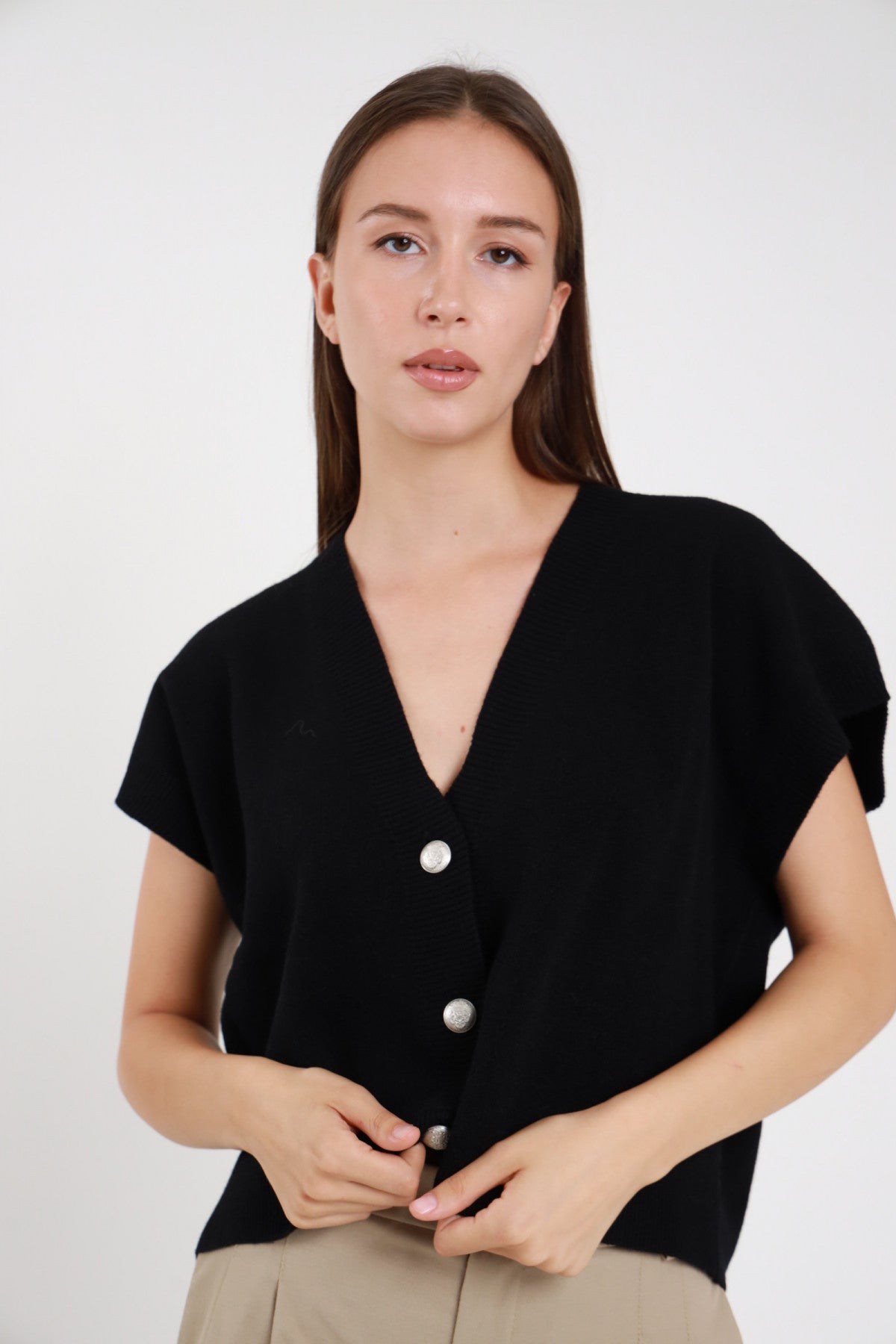 Gilet maglia nero scollo a V bottoni argentati donna Susy Mix – vista frontale con pantaloni beige