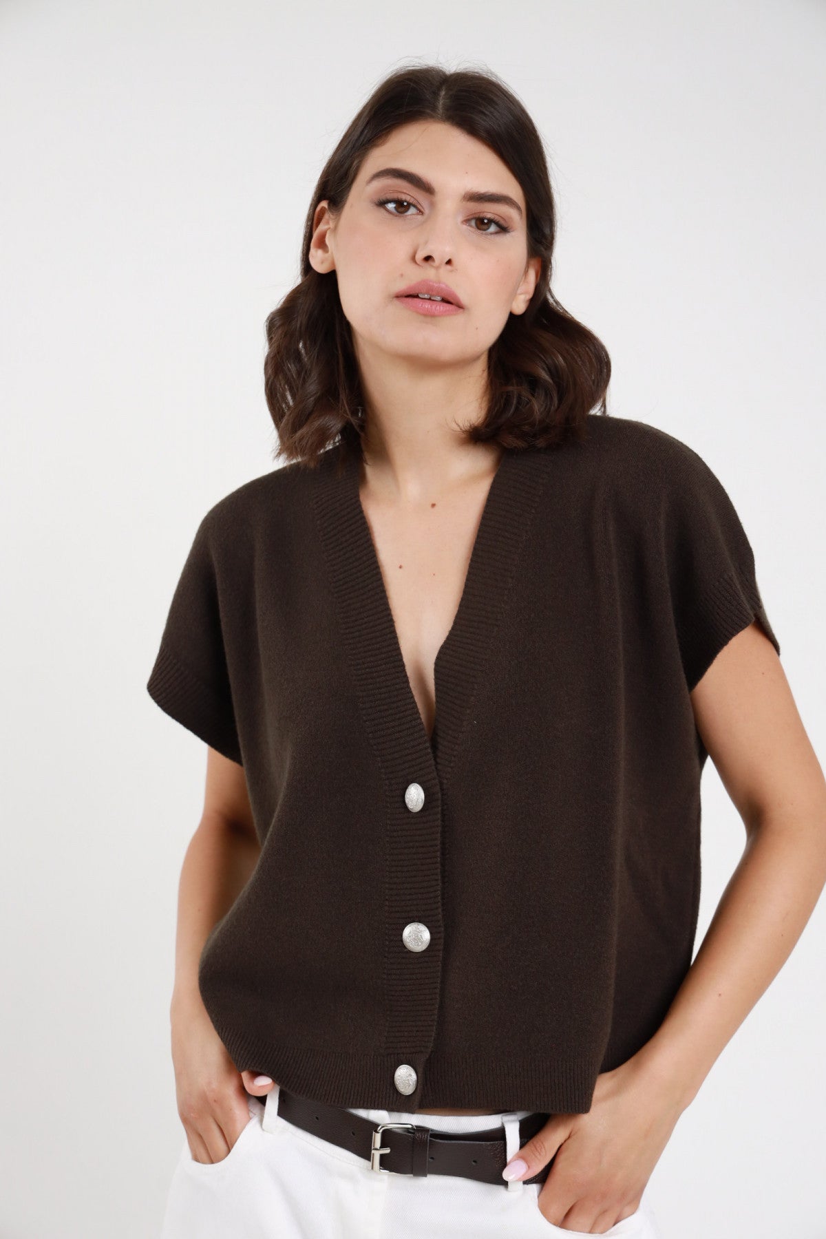 Gilet maglia marrone cioccolato scollo a V bottoni argentati donna Susy Mix – vista frontale con pantaloni bianchi