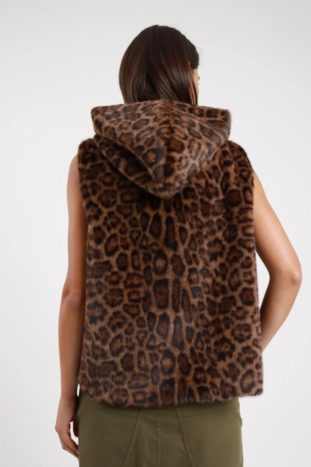 Gilet ecopelliccia animalier leopard cappuccio Susy Mix Pre-Fall stampa maculata leopard marrone nero ecopelliccia fluffy morbida cappuccio integrale retro posteriore intera - modella posteriore intera capelli scuri lisci sfondo bianco cappuccio ampio retro pantaloni verde militare abbinati