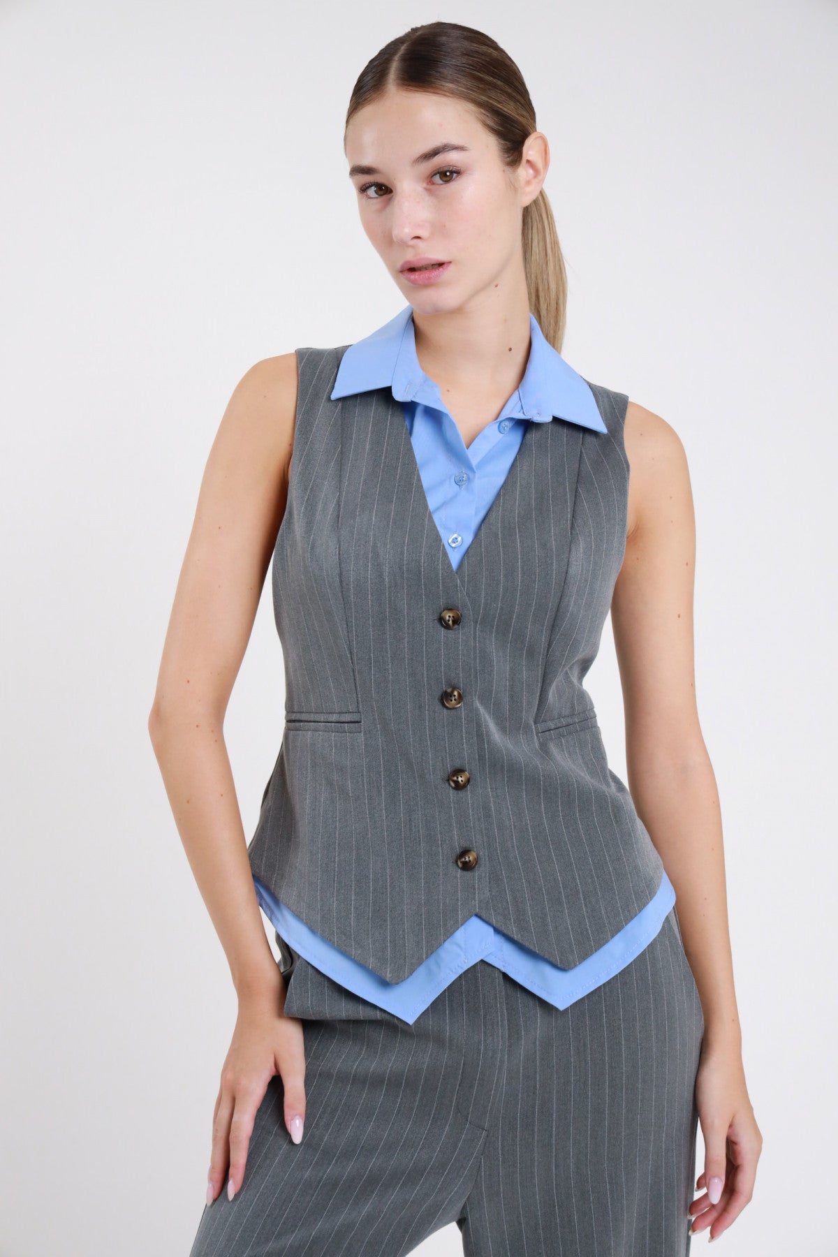 Gilet gessato grigio set camicia azzurra - modella vista frontale con pantaloni gessati grigi coordinati
