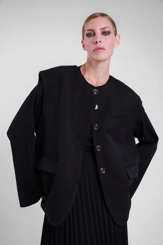 Gilet over Susy Mix nero con bottoni e patte laterali, indossato sopra una maglia nera