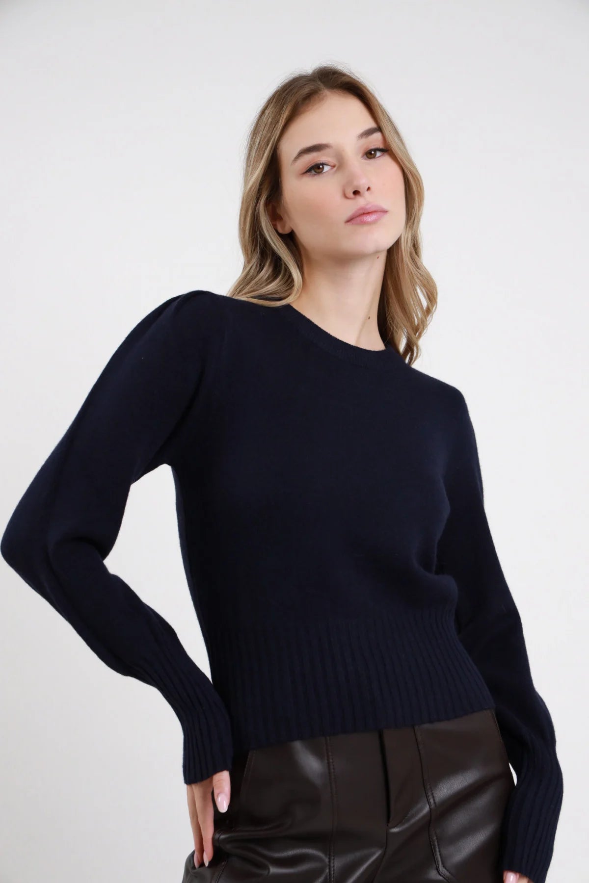Pullover Maniche Palloncino nero 45% viscosa girocollo manica puff palloncino spalla polsino costina largo bordo costina boxy frontale busto braccia incrociate - modella busto frontale braccia incrociate sguardo intenso capelli castani scuri lisci sfondo bianco pantaloni cargo animalier verde militare abbinati