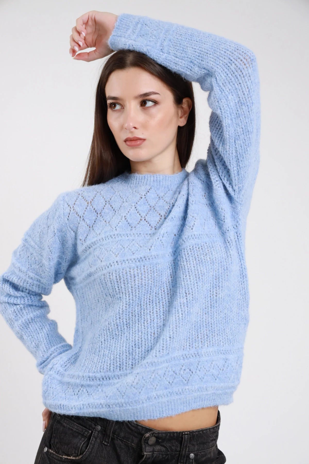 Pullover traforato azzurro baby blue frontale tre quarti mano alzata girocollo lavorazione pointelle rombi argyle manica dropped shoulder balloon polsino coste orlo coste crop - modella frontale tre quarti mano alzata sguardo laterale basso jeans neri capelli castani lisci