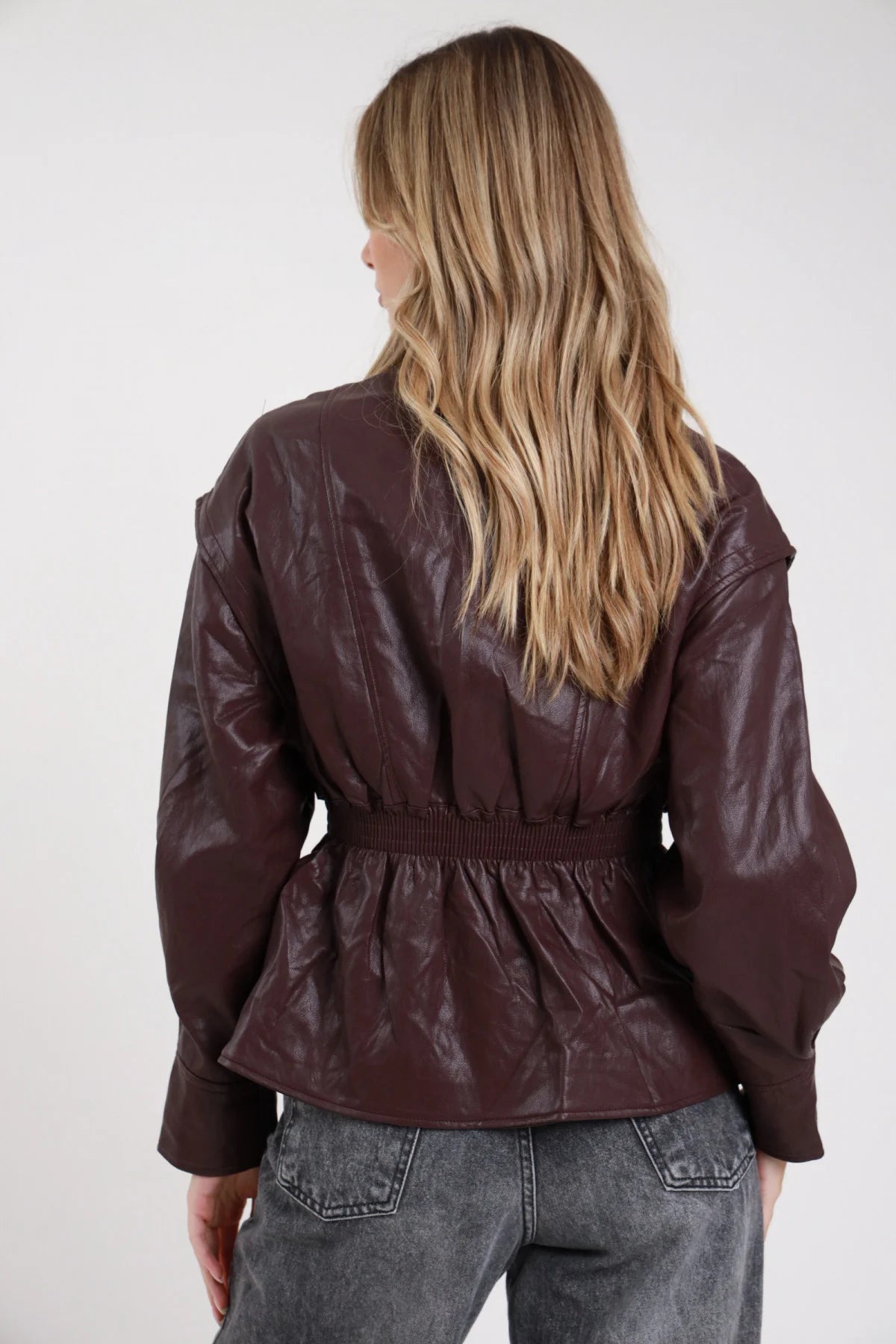 Giacca ecopelle bordeaux vino scuro retro maniche batwing elastico vita - modella retro intera jeans grigi capelli biondi mossi lunghi