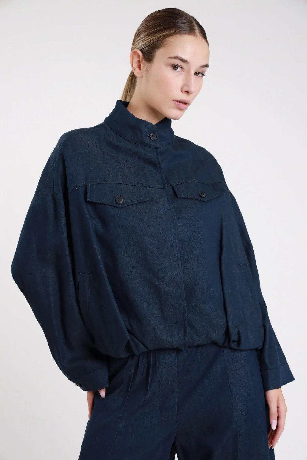 Bomber oversize blu navy spina di pesce - modella busto tre quarti con pantaloni navy coordinati e maniche palloncino