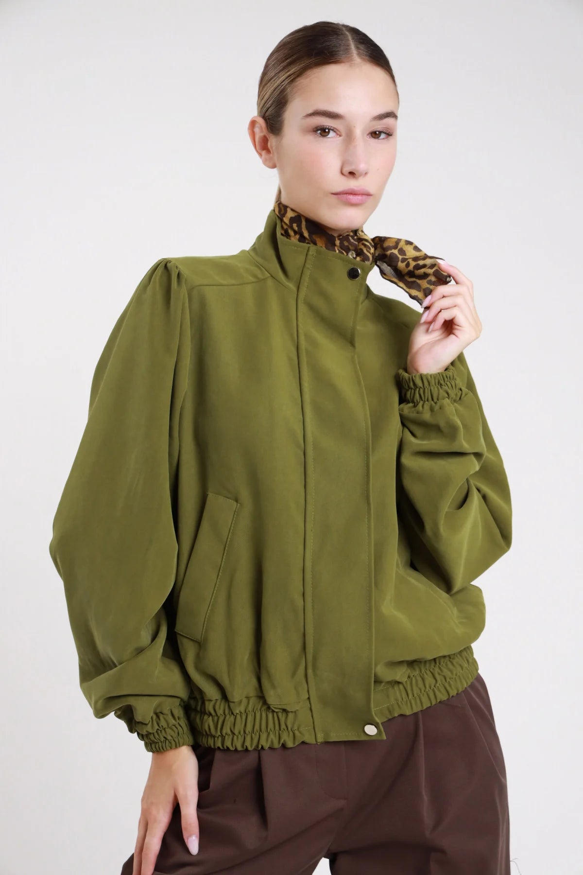 Giacca bomber viscosa suede cioccolato moro frontale busto mani fianchi foulard satin leopardato annodato collo alto snap corpo oversize boxy - modella frontale busto mani fianchi foulard leopard sguardo frontale gonna cioccolato capelli biondi mossi