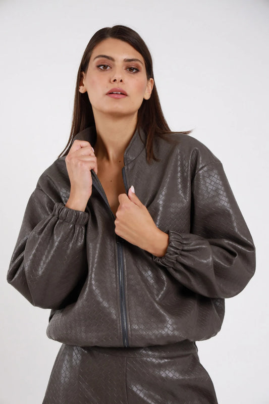 Bomber Ecopelle Intrecciato grigio talpa taupe woven embossed romboidale oversize boxy crop zip aperta mani colletto manica balloon polsino arricciato busto frontale 3/4 - modella busto frontale 3/4 mani zip sguardo frontale capelli castani lisci sfondo bianco pantalone coordinato grigio