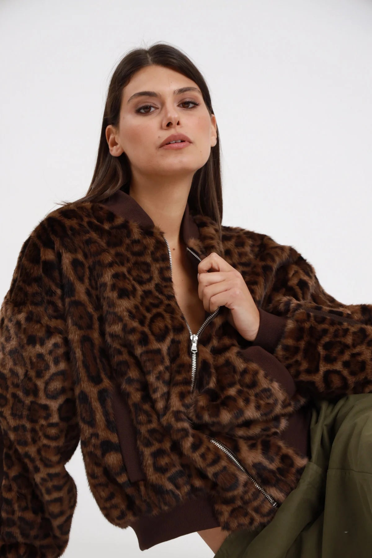 Bomber ecopelliccia animalier leopard Susy Mix Pre-Fall 100% poliestere stampa maculata leopard marrone tabacco nero colletto bomber costine marrone zip frontale cursore argento maniche ampie busto 3/4 mano zip sguardo laterale - modella busto 3/4 mano zip sguardo laterale capelli scuri lisci sfondo bianco gonna tasche verde militare abbinata