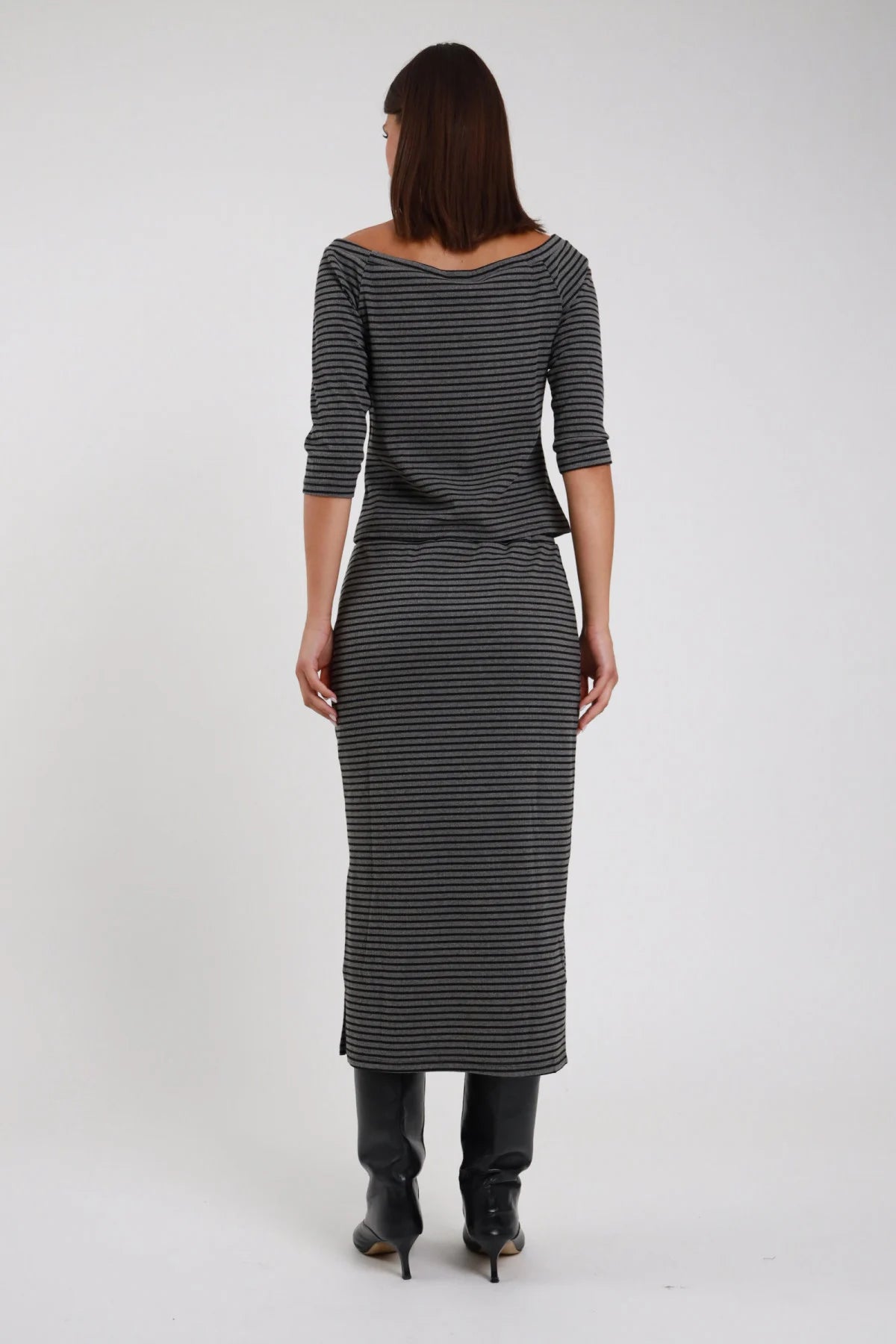 Gonna Midi Longuette Righe grigio antracite nero lurex 48% cotone elastico vita silhouette longuette semi-aderente spacco laterale posteriore - modella intera posteriore posa statica capelli castani lisci sfondo bianco top righe grigio coordinato stivali neri ginocchio tacco