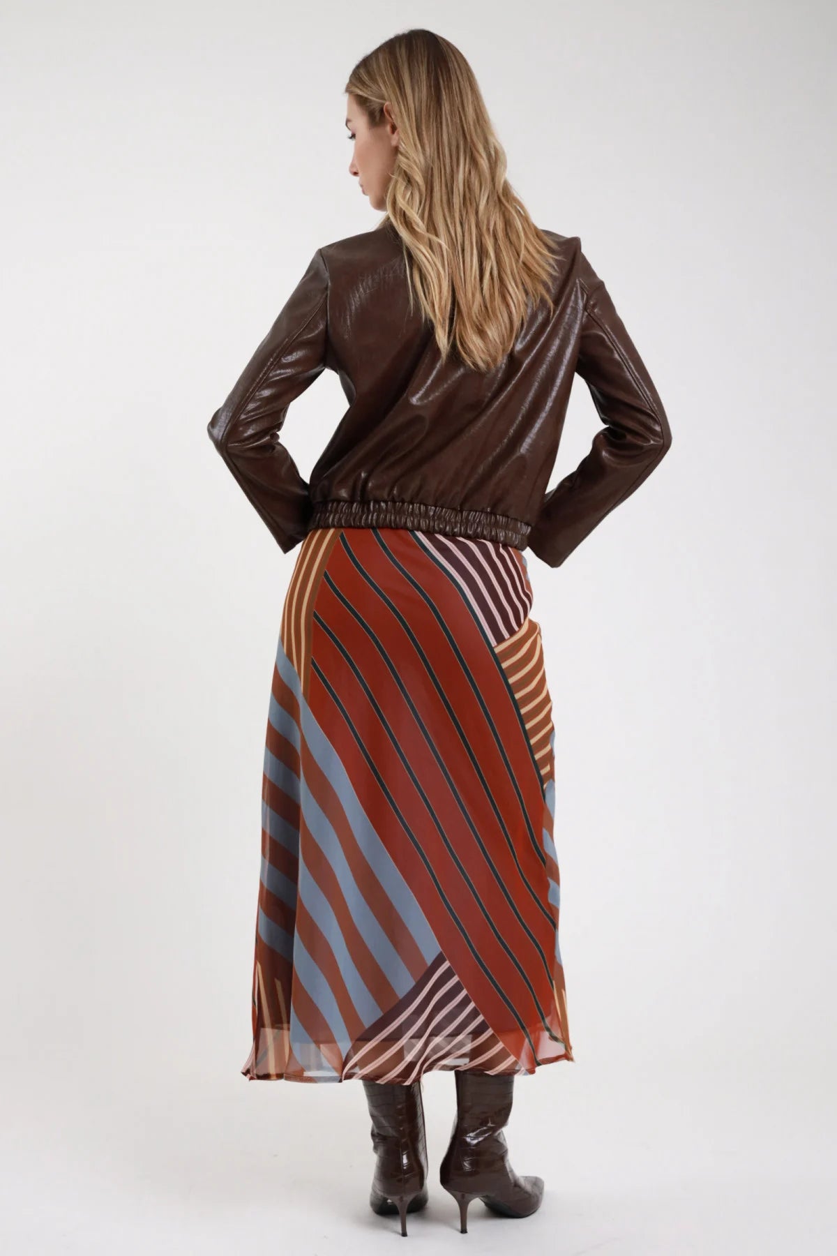 Gonna fantasia righe patchwork retro a-line elastico vita smock giacca pelle - modella retro intera mani ai fianchi sguardo posteriore giacca marrone stivali croco capelli biondi