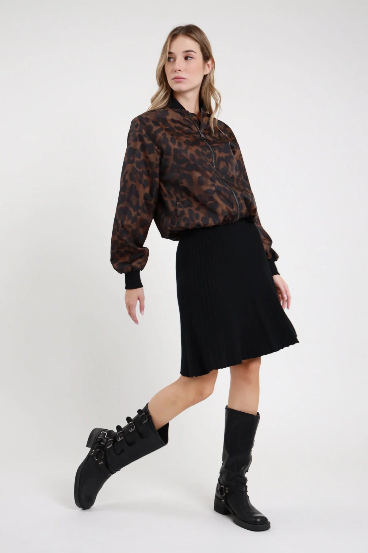 Gonna Midi Coste Plissé beige sabbia 52% viscosa coste verticali plissé fitte elastico vita invisibile silhouette A-line svasata lunghezza midi - modella intera frontale posa mano fianco sguardo basso soft capelli biondi mossi sfondo bianco camicia scozzese marrone stivali neri