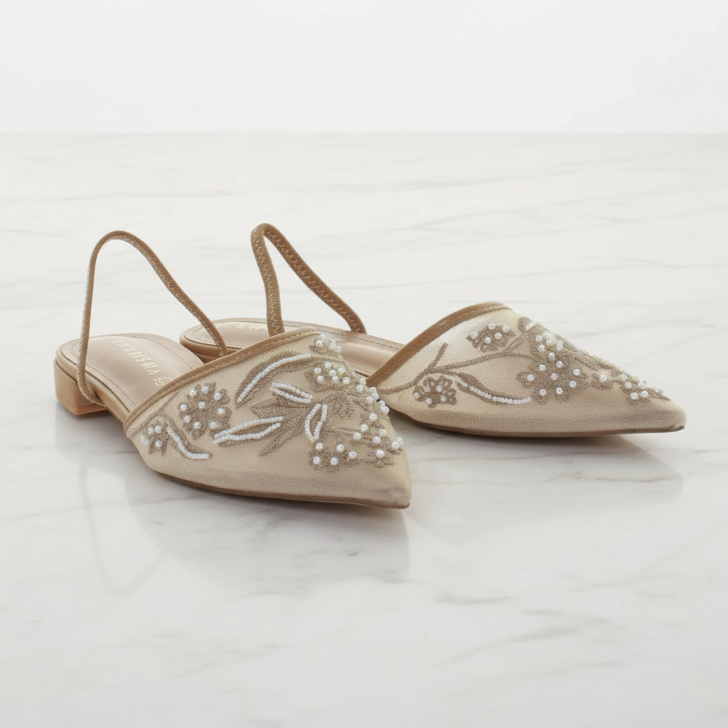 Coppia di ballerine slingback rete perline beige su pavimento in marmo