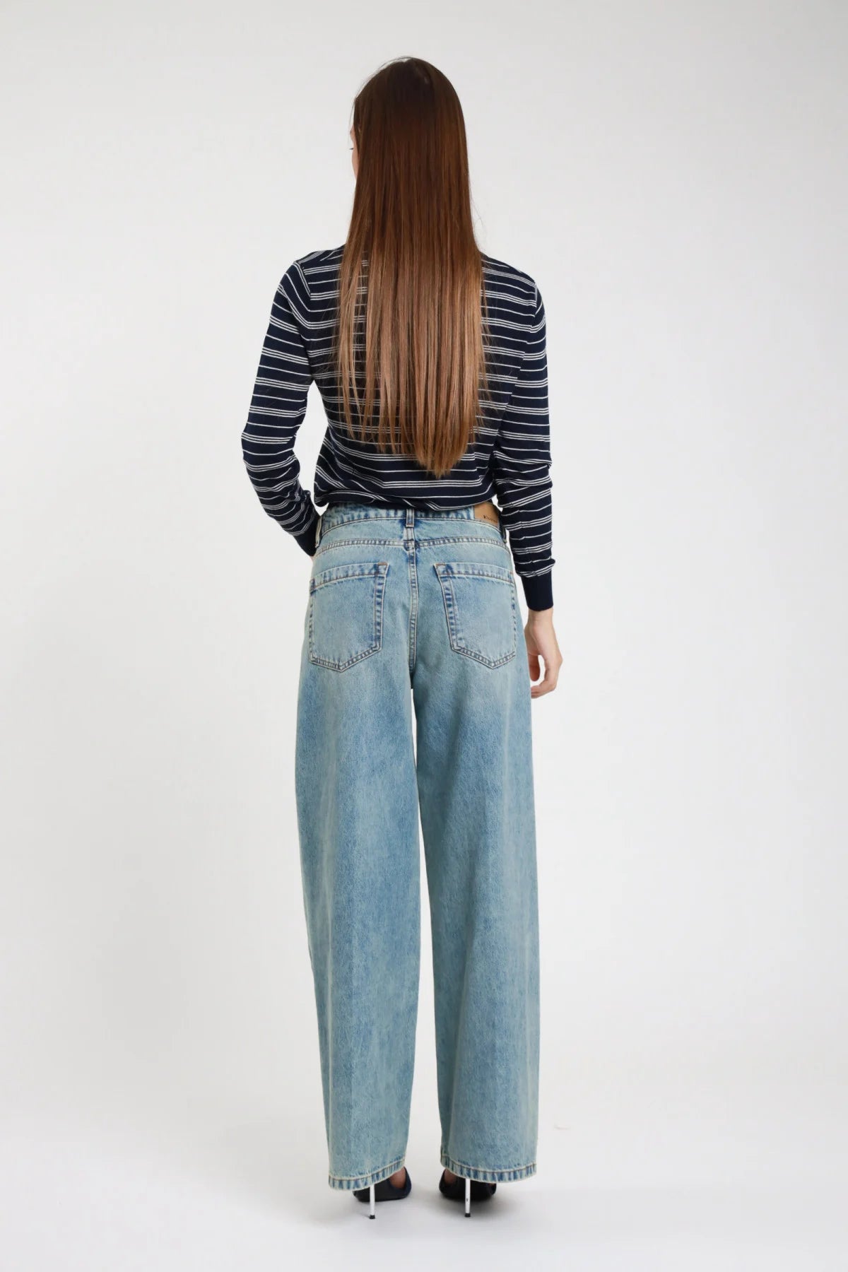 Jeans dritto wide leg palazzo blu chiaro lavato donna vita media fondo sfrangiato - vista posteriore con polo righe navy e sandali neri