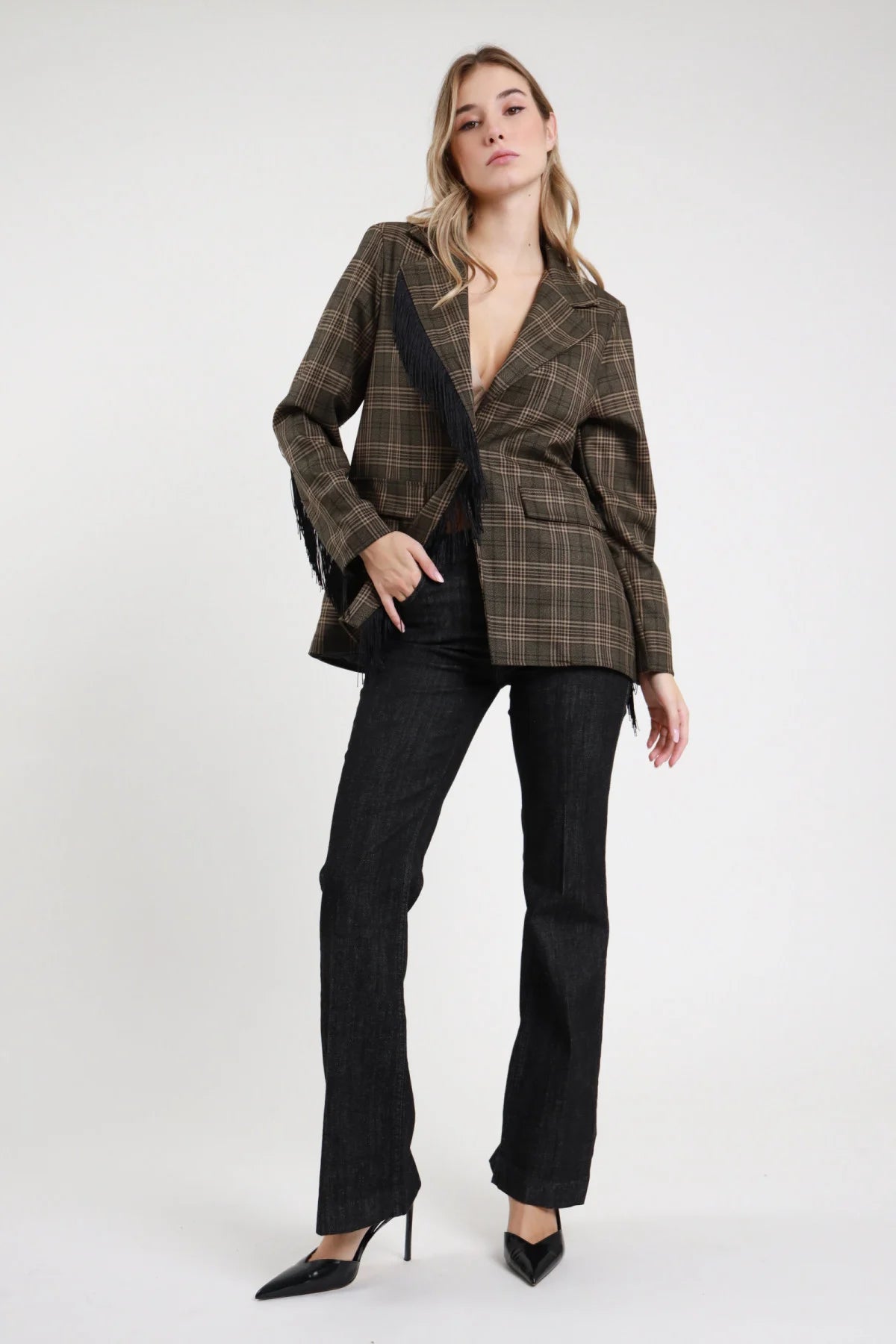 Jeans Emily Flare nero antracite dark raw 98% cotone vita alta zip bottone tasche frontali filo gamba flare molto svasata lunghezza floor length frontale intera mano tasca - modella intera frontale mano tasca sguardo frontale capelli biondi mossi sfondo bianco blazer check frange coordinato décolleté punta neri