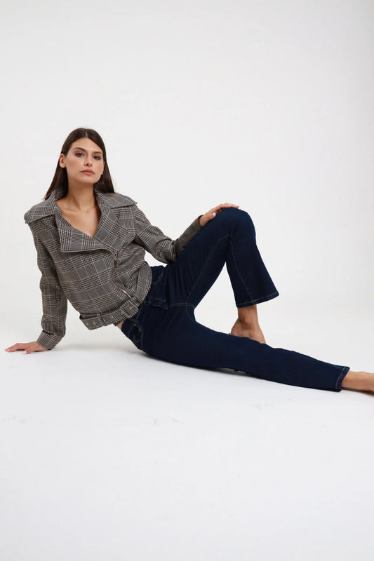 Jeans Ery Flare bootcut blu navy dark wash indigo 98% cotone intera seduta pavimento 3/4 laterale gamba flare vita alta lunghezza crop 7/8 scalza - modella intera seduta pavimento 3/4 laterale sguardo frontale intenso capelli castani scuri bob sfondo bianco blazer prince of wales aperto cintura