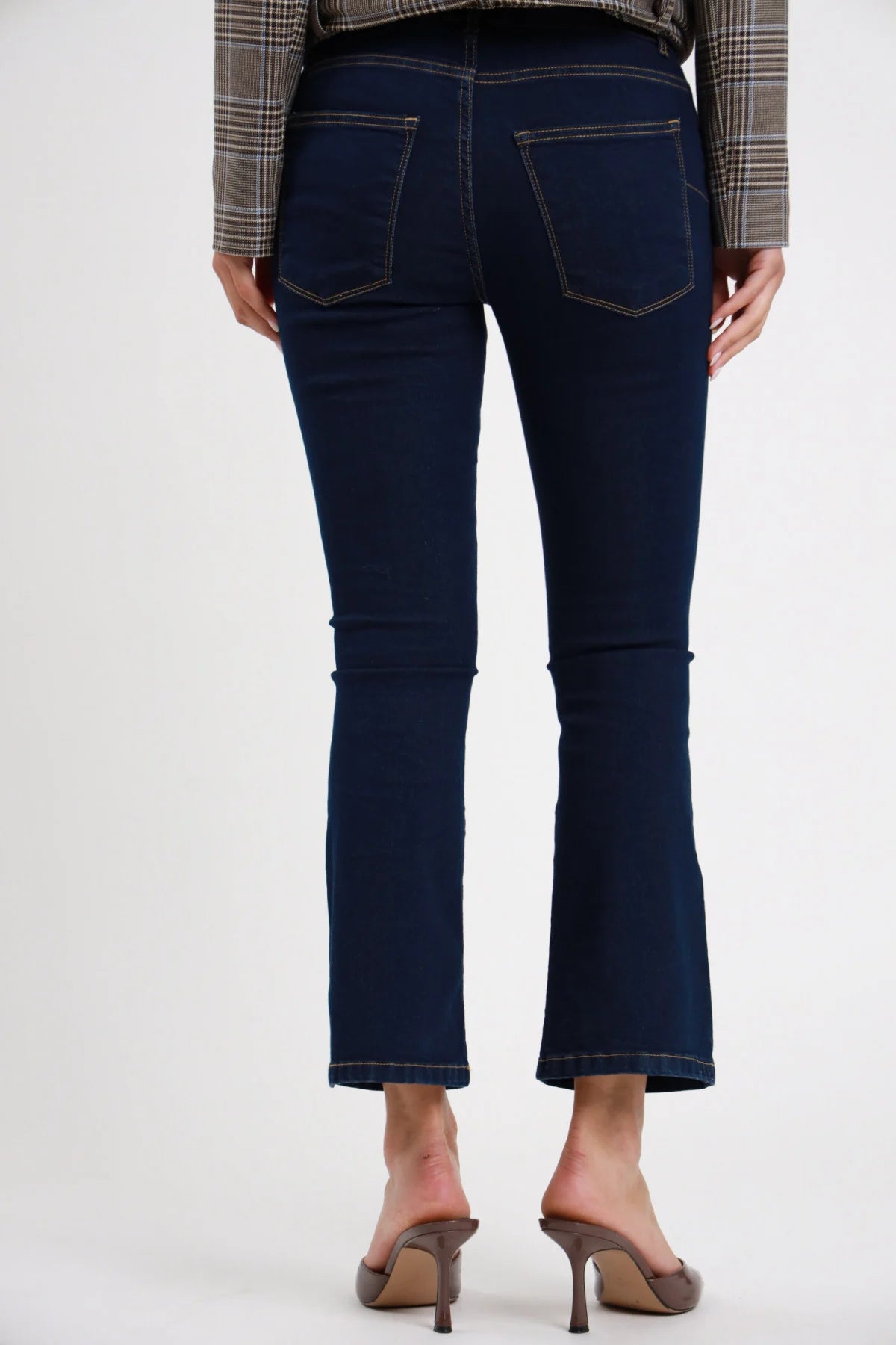 Jeans Ery Flare bootcut blu navy dark wash indigo 98% cotone dettaglio posteriore ravvicinato tasche posteriori quadrate topstitching oro beige gamba flare compatta denim scuro - modella dettaglio posteriore gamba capelli castani scuri bob sfondo bianco