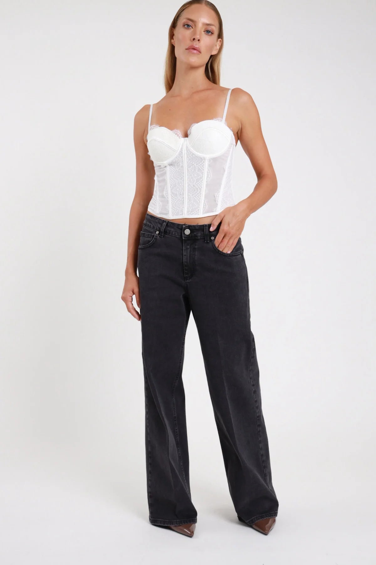 Jeans palazzo wide-leg nero washed frontale intera mid-rise silhouette ampia full-length - modella frontale intera sguardo frontale top bustino bianco stivaletti tacco marrone capelli biondi lisci