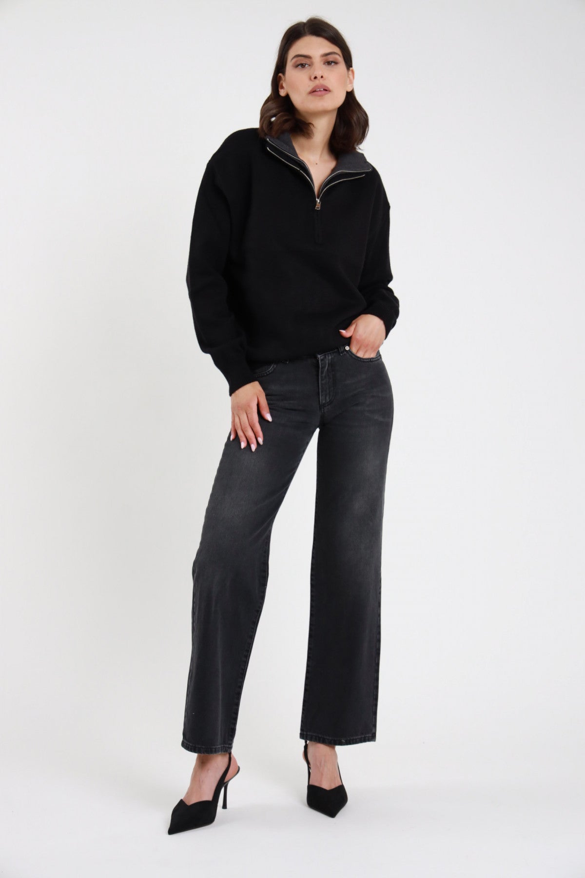 Jeans Debby Straight nero washed stone wash 5 tasche vita media orlo grezzo raw hem gamba dritta relaxed frontale intera in piedi mano tasca - modella frontale intera mano tasca sguardo frontale capelli castani sfondo bianco half-zip maglia nero décolleté nere