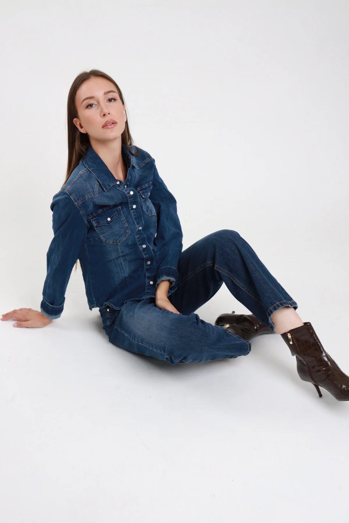Jeans Manu straight blu medio lavato donna vita alta gamba dritta cropped - vista tre quarti seduta sul pavimento total denim con stivali marroni