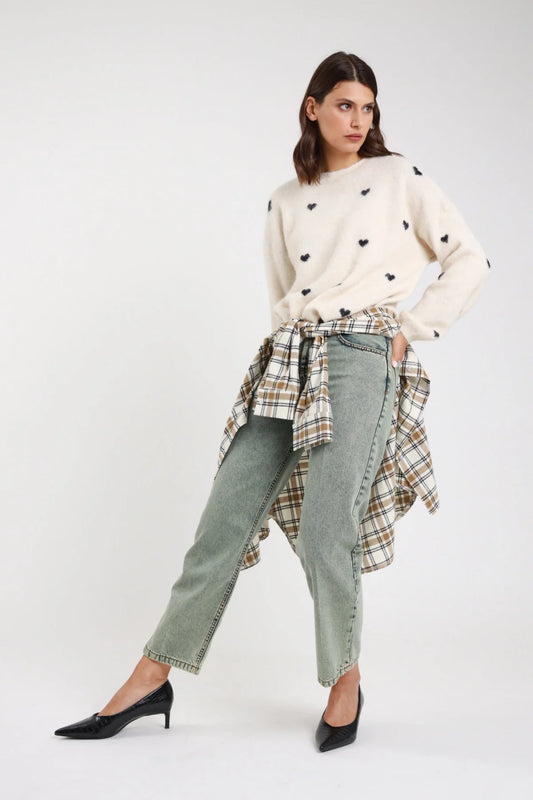 Jeans Manu straight leg verde sage acqua stonewashed rhinestone vita alta 5 tasche orlo grezzo frontale intera con pullover cuori avorio - modella frontale intera sguardo laterale capelli castani scuri mossi sfondo bianco pullover cuori avorio camicia check annodata vita décolleté neri kitten heel