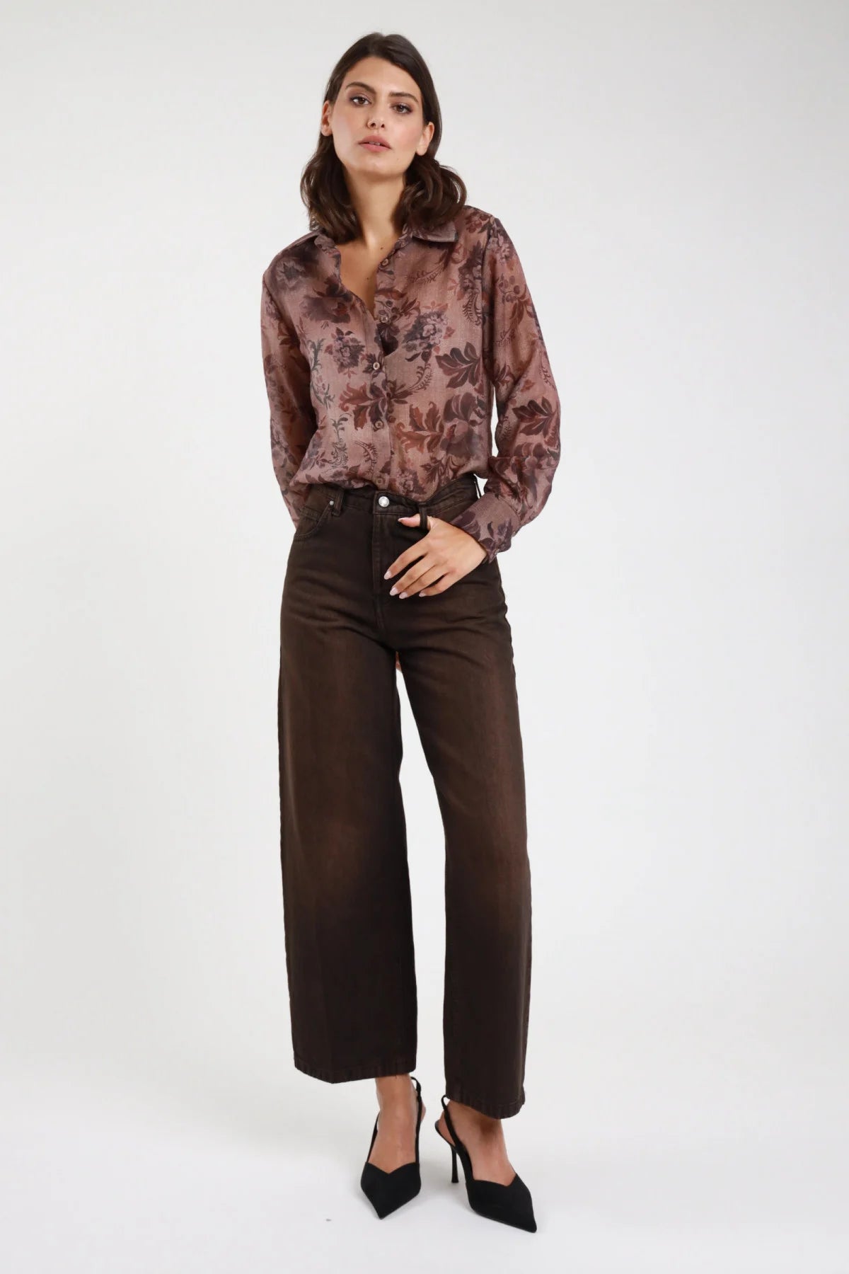 Jeans Cinzia wide leg marrone cioccolato donna vita alta 5 tasche gamba larga cropped caviglia - vista frontale intera mano in tasca con camicia fantasia floreale e décolleté neri