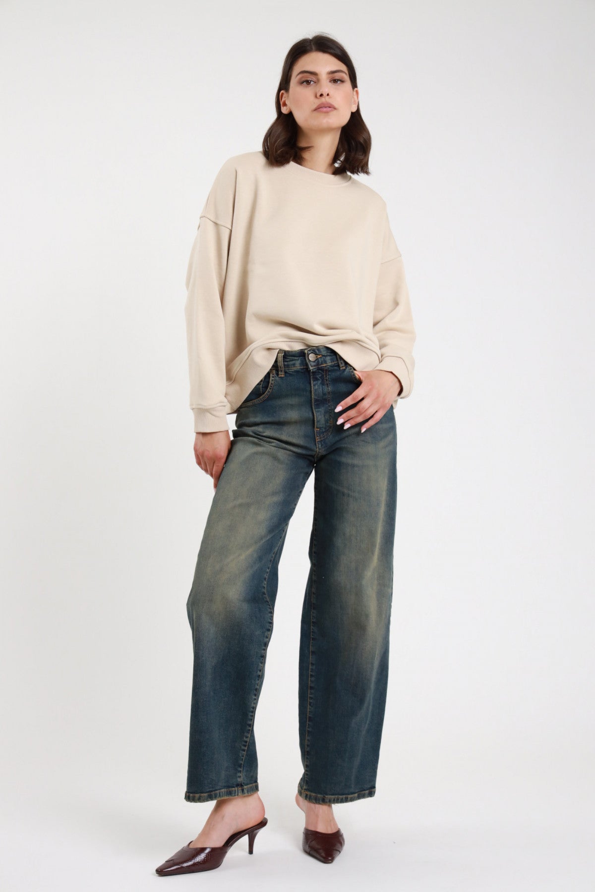 Jeans Eddie Wide Leg denim indaco blu petrol sovratinto vintage vita media 2 bottoni gamba larga orlo grezzo sfrangiato frontale intera in piedi - modella frontale intera sguardo frontale capelli castani scuri sfondo bianco felpa oversize panna mule kitten heel marrone
