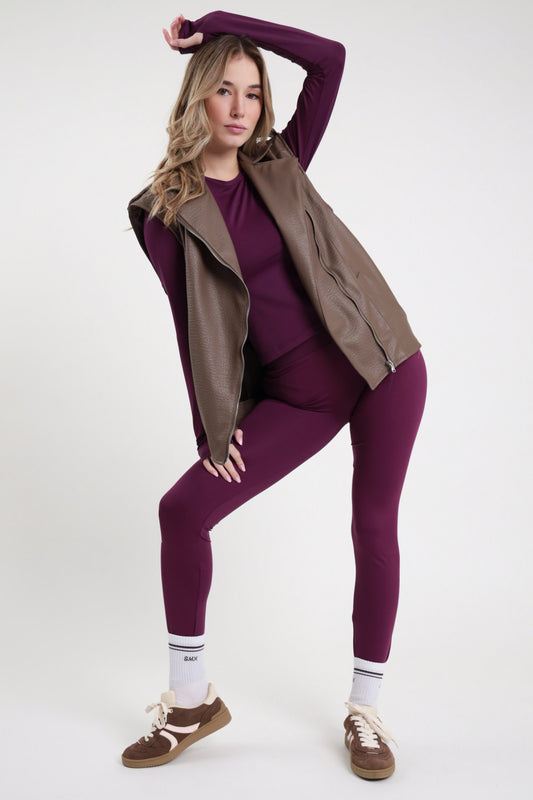 Leggings SMX Limited Edition viola melanzana 95% tactel vita alta body line logo SMX bianco coscia laterale full length caviglia frontale intera braccio alto - modella intera frontale braccio alto testa mano capelli biondi mossi sfondo bianco maglia second skin manica lunga viola coordinata gilet biker pelle tortora camel zip calzini SMX bianchi sneakers Samba marrone beige abbinati